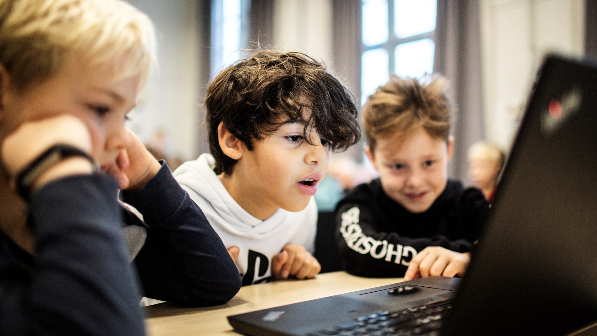Drenge ser på en computerskærm i en dansk folkeskole